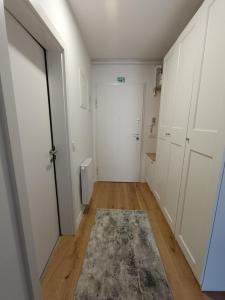 einen leeren Flur mit Tür und Teppich in der Unterkunft Apartman LEO in Velika Gorica
