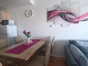 a dining room table with a vase of flowers on it at Apartman LEO in Velika Gorica