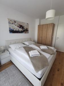 a bedroom with a large white bed with towels on it at Apartman LEO in Velika Gorica