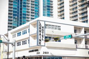 um edifício branco com uma grande placa sobre ele em Lorraine Hotel em Miami Beach