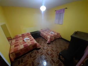 Hotel Posada San Felipe في أنتيغوا غواتيمالا: غرفة بسريرين في غرفة بها ضباب