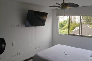 a bedroom with a bed and a flat screen tv at Apartamento en Cañaveral in Floridablanca