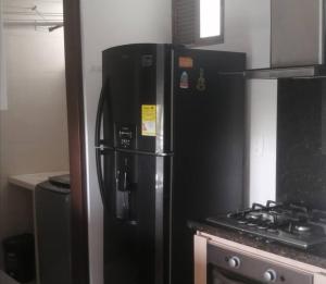 a black refrigerator in a kitchen next to a stove at Apartamento en Cañaveral in Floridablanca