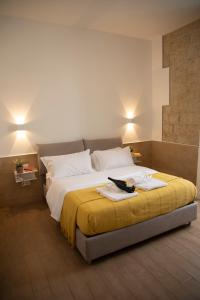 una camera da letto con un grande letto con una coperta gialla di H22 Hotel a Napoli