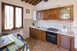 een keuken met een wastafel en een fornuis top oven bij Casa Galina in Ciggiano