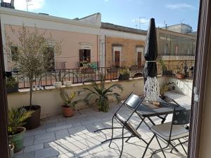 patio con mesa y sillas en el balcón en La Casa Di Chia, en Trepuzzi