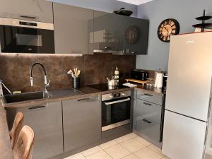 a kitchen with a sink and a refrigerator at Maison COMet avec jardin et parking in Orléans