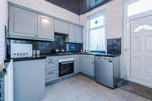 a kitchen with white cabinets and a window at Stunning three Bed House in Bradford in Bradford