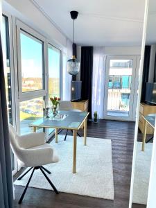 Helles Apartment über den Dächern Rostocks في روستوك: غرفة معيشة مع طاولة وكراسي في غرفة