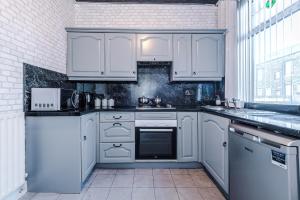 a white kitchen with white appliances and a window at Stunning three Bed House in Bradford in Bradford