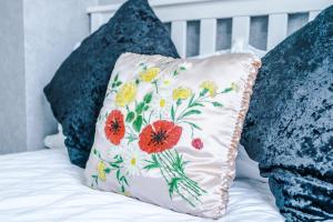 a pillow with flowers on it sitting on a bed at Stunning three Bed House in Bradford in Bradford