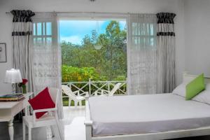 a bedroom with a bed and a desk and a window at Mount edge riverside hotel in Bandarawela in Bandarawela