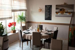 Gironcourt-sur-VraineにあるLogis Hôtel Restaurant La Vraineのダイニングルーム(テーブル、椅子付)