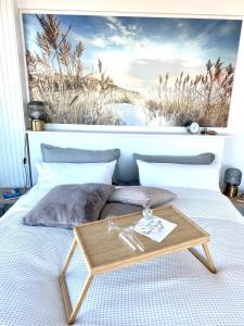 a bed with a wooden tray on top of it at Helles Apartment über den Dächern Rostocks in Rostock