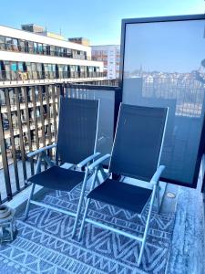 2 sillas en la parte superior de un balcón en Helles Apartment über den Dächern Rostocks, en Rostock