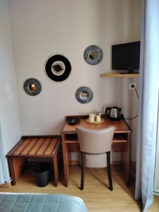 Cénac-et-Saint-JulienにあるHotel Restaurant La Traverseのデスク、テーブル、椅子が備わる客室です。