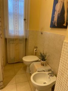 a bathroom with a sink and a toilet and a window at La casa di Nana’ in Pisa