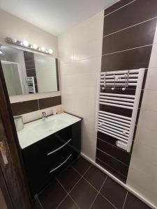 La salle de bains est pourvue d'un lavabo et d'un miroir. dans l'établissement Le Sarana : 75m2, calme, belle vue avec terrasse., à Les Deux Alpes
