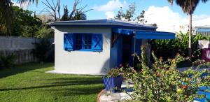 a blue and white dog house in a yard at Idéal pour séjour professionnel ou touristique in Baie-Mahault