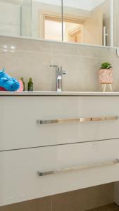 un bancone del bagno con lavandino e specchio di Luxury Apartment in Garitsa Bay a Città di Corfù