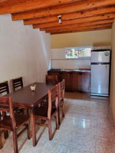 a kitchen with a wooden table and a refrigerator at RESIDENCIAL LOS ANDES in Jardín América
