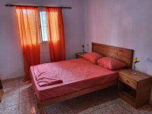 a bedroom with a bed with red sheets and a window at RESIDENCIAL LOS ANDES in Jardín América