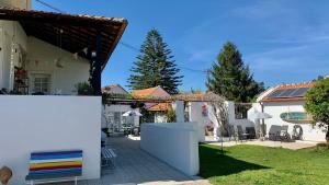 a white house with a yard with a fence at Casa do Paço Aveiro - HolidayHome in Aveiro