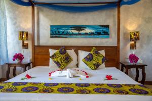 una camera da letto con un letto e due asciugamani di Mawimbi Bungalows a Nungwi
