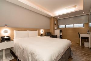 Habitación de hotel con cama grande y escritorio. en HUB HOTEL Tucheng, en Tucheng