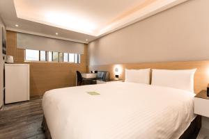 土城區的住宿－旅居文旅土城館，酒店客房设有一张大床和一张书桌。