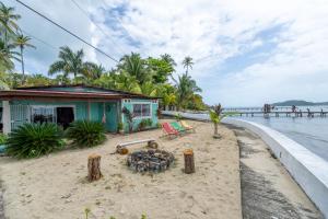 a house on the beach next to the water at Casa del Fuego - Caribbean Beachfront Magic! in Bocas del Toro
