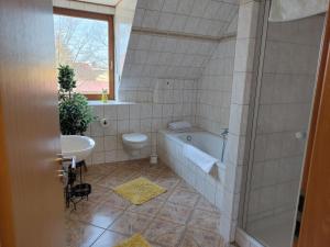 uma casa de banho com uma banheira, um WC e um lavatório. em Ferienwohnung Hohenroda em Hohenroda