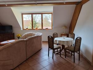 sala de estar con sofá, mesa y sillas en Ferienwohnung Hohenroda, en Hohenroda