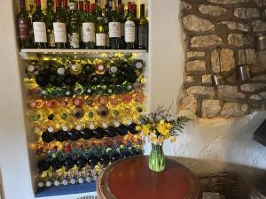 un montón de botellas de vino en una pared con una mesa en The Talbot Inn en Eynsham