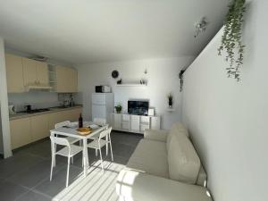 Tenerife Primavera في أرونا: مطبخ وغرفة معيشة مع أريكة وطاولة