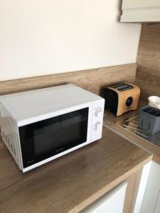 a microwave oven sitting on a counter in a kitchen at Kiad-Lak Apartman in Szeged