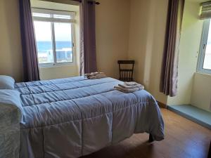 a bedroom with a bed and a large window at Casa Fagundes in Faja Grande