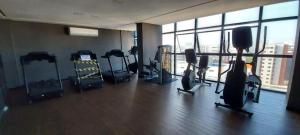 a gym with cardio equipment and a large window at Std Time Maceió in Maceió