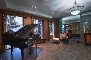 a living room with a piano and a chair at Maldini 1899 Boutique Hotel in Krasnodar