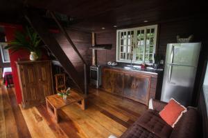 eine Küche mit einem Sofa, einem Kühlschrank und einem Tisch in der Unterkunft Rain Forest Paradise in Rio de Janeiro