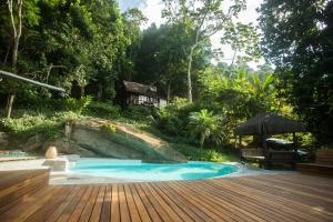 einem Pool mit Holzterrasse und einem Haus in der Unterkunft Rain Forest Paradise in Rio de Janeiro