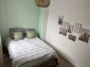 1 dormitorio con 1 cama con cuadros en la pared en Le phare, en Yport