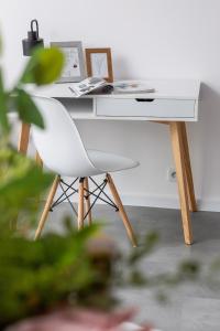 einen weißen Schreibtisch mit einem weißen Stuhl in einem Zimmer in der Unterkunft Lux Apartment Grzegórzecka Estate Cracow by Renters Prestige in Krakau