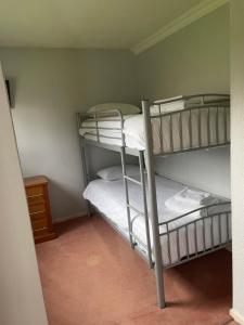 a room with two bunk beds with white sheets at The Conningbrook Hotel in Ashford