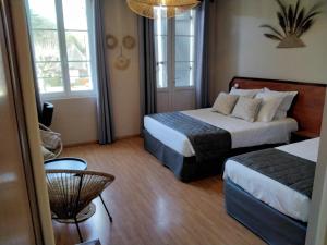 ein Hotelzimmer mit 2 Betten und einem Tisch in der Unterkunft Hotel Restaurant La Traverse in Cénac-et-Saint-Julien