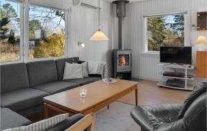 ein Wohnzimmer mit einem Sofa, einem Tisch und einem Kamin in der Unterkunft Awesome Home In Nakskov With Wifi in Nakskov