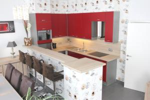 une cuisine avec des placards rouges et un comptoir dans l'établissement Cityloft, à Ypres