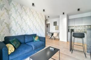 uma sala de estar com um sofá azul e uma mesa em LTC - Apartments Art Deco Śródmieście em Gdynia