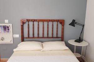 a bed with a wooden headboard in a bedroom at Casa para vacaciones o estancias cortas in Barrio de las Cuevas