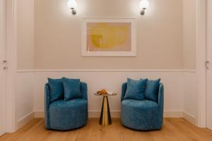 two blue chairs and a table in a room at Sonder Antinoo in Rome